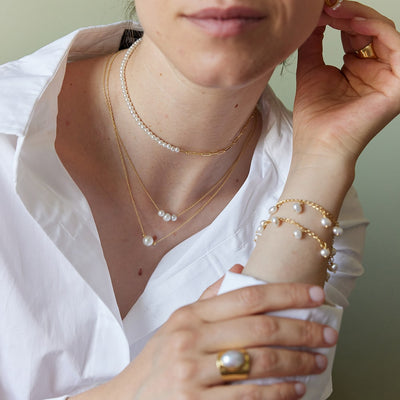 A modern twist on the classic pearl necklace, the Laura Gold Chain Necklace features a vintage white pearl and two gold beads. This very delicate sustainable necklace is all about simplicity.&nbsp;